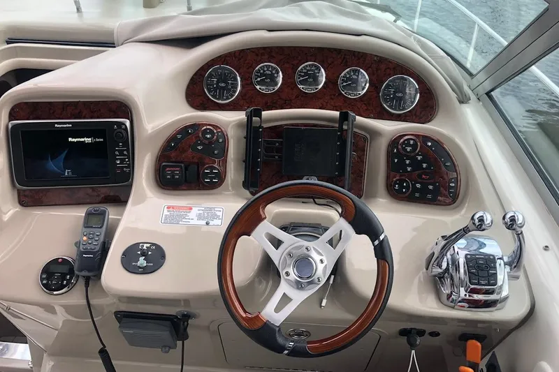 Slide: The Image of 2008 Sea Ray 340 Sundancer helm with wood accents and modern navigation controls. - 10