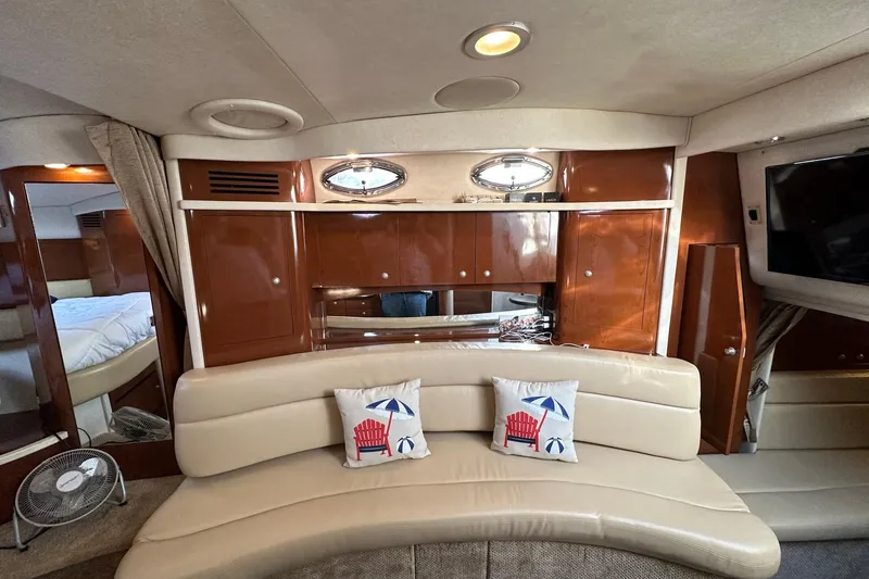 Slide: The Image of Interior of 2008 Sea Ray 340 Sundancer with beige seating and nautical-themed pillows. - 17