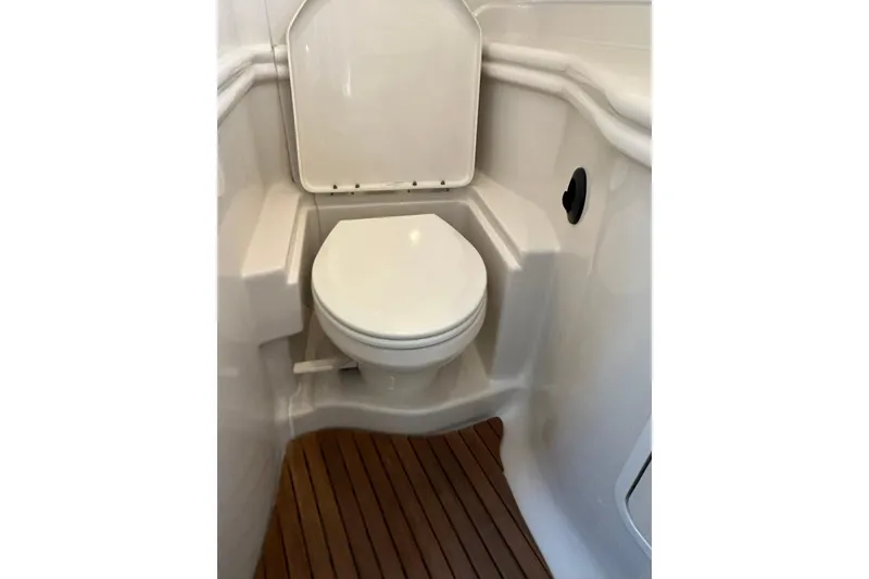 Slide: The Image of 2008 Sea Ray 340 Sundancer boat bathroom with white toilet and wooden floor. - 22