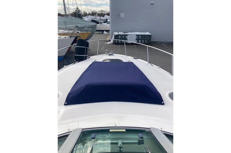 Slide: The Image of 2008 Sea Ray 340 Sundancer boat with blue cover on deck, docked at marina. - 8