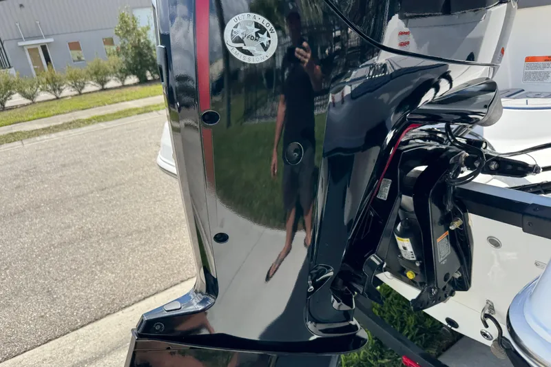 Slide: The Image of 2024 Tahoe 185 S boat engine with ultra-low emission sticker, reflecting surroundings. - 13