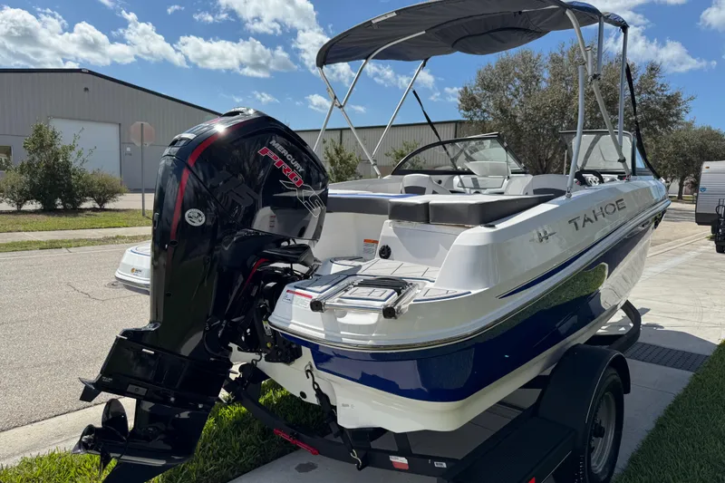 Slide: The Image of 2024 Tahoe 185 S boat with Mercury engine, parked outdoors under a clear sky. - 15