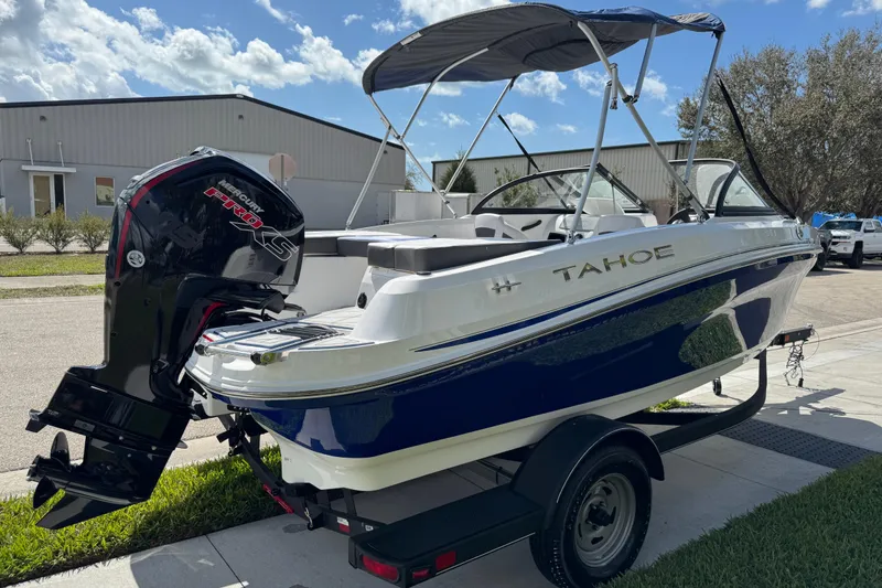 Slide: The Image of 2024 Tahoe 185 S boat with Mercury engine on trailer, parked outdoors. - 16