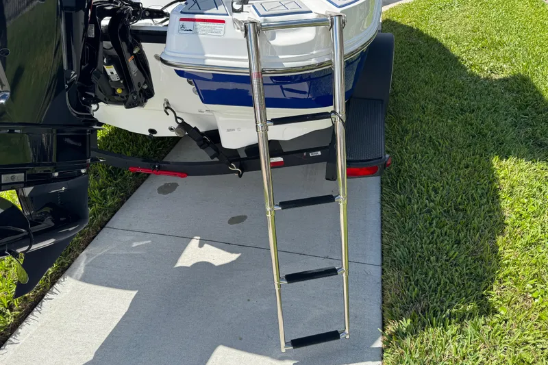 Slide: The Image of 2024 Tahoe 185 S boat with ladder on trailer, parked on grass. - 30