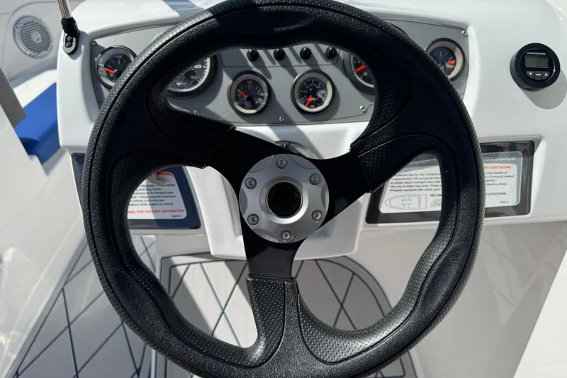 Slide: The Image of Steering wheel and dashboard of 2024 Tahoe 185 S boat, featuring gauges and controls. - 47