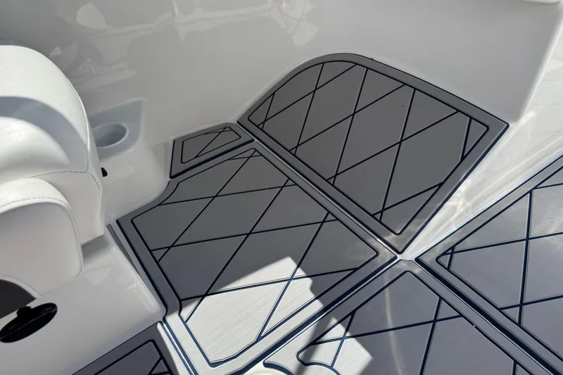Slide: The Image of 2024 Tahoe 185 S boat interior with stylish, diamond-patterned flooring and white seating. - 49