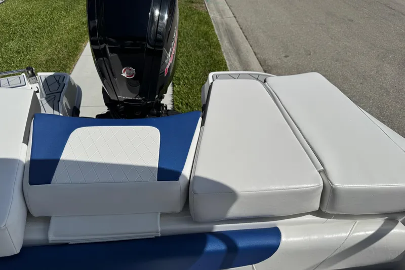 Slide: The Image of 2024 Tahoe 185 S boat with cushioned seating and outboard motor, parked on pavement. - 65