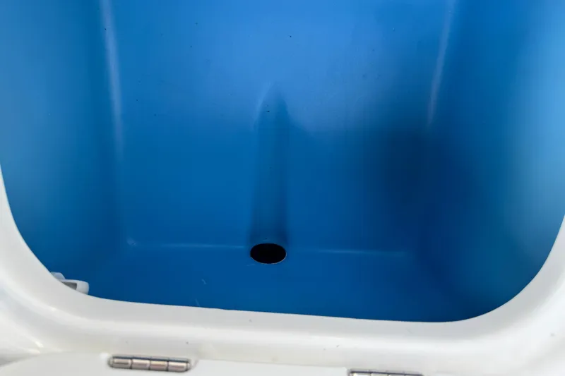 Slide: The Image of 2024 Tahoe 185 S boat storage compartment with blue interior and drain hole. - 66