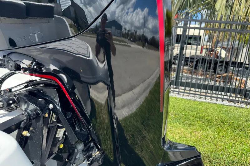Slide: The Image of 2024 Tahoe 185 S boat engine detail with reflection, outdoors on a sunny day. - 7