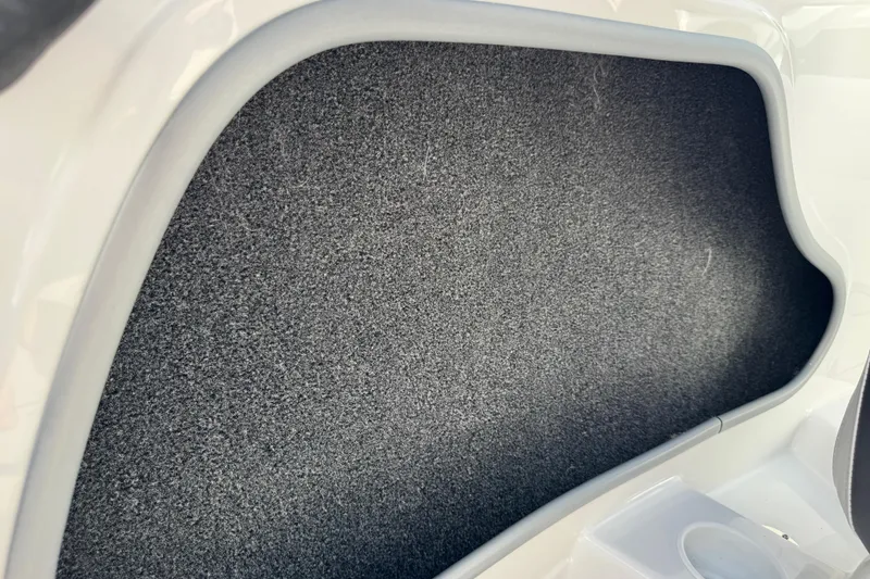 Slide: The Image of Interior storage compartment of 2024 Tahoe 185 S boat, featuring gray carpet lining. - 70
