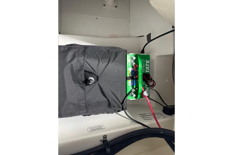 Slide: The Image of Battery compartment of 2024 Tahoe 185 S boat with wiring and cover. - 96