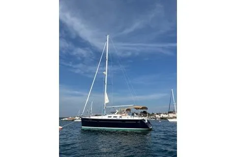 Slide: The Image of 2006 Beneteau 373 sailboat on calm water under a clear blue sky. - 12
