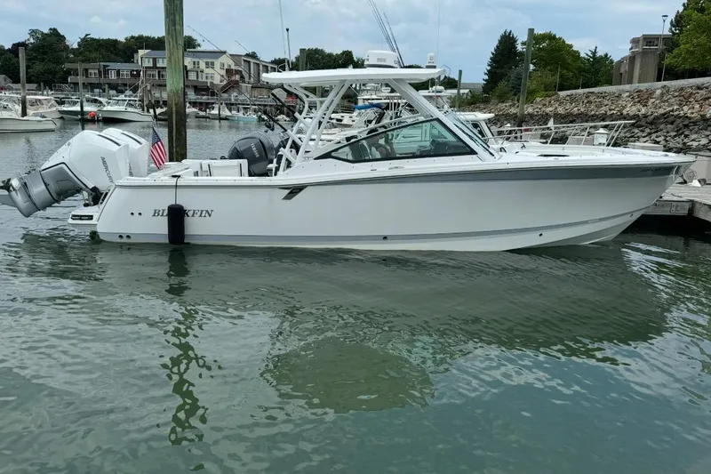 The Image of 2024 Blackfin 302 DC boat docked in a marina, showcasing sleek design and powerful engines. - 0