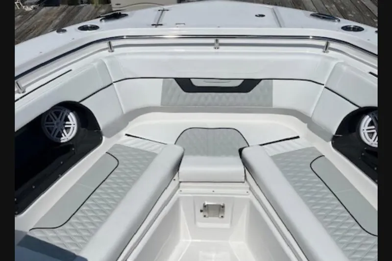 Slide: The Image of 2024 Blackfin 302 DC boat interior with cushioned seating and built-in speakers. - 18