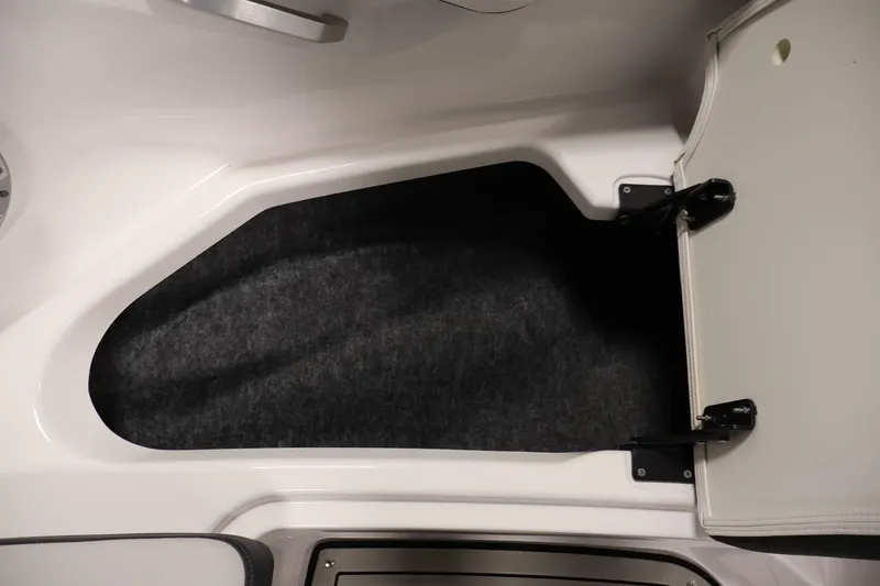 Slide: The Image of Open storage compartment in 2020 Yamaha Boats 195S, featuring carpeted interior and hinged door. - 16