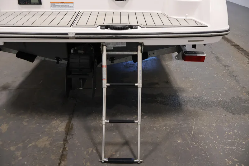 Slide: The Image of 2020 Yamaha Boats 195S swim platform with retractable ladder in a garage setting. - 46