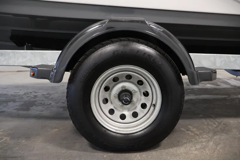 Slide: The Image of Trailer wheel of 2020 Yamaha Boats 195S, featuring Carlisle tire and metal fender. - 49