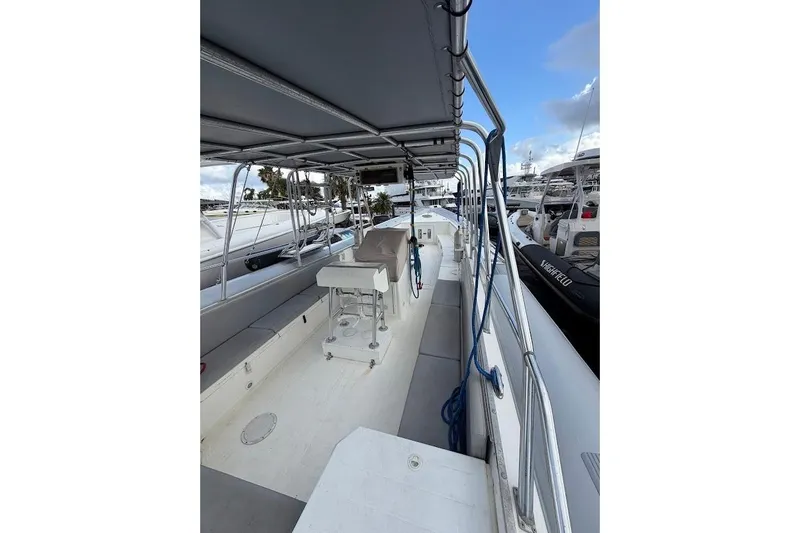 Slide: The Image of 2009 Eduardono RIB boat interior with seating and canopy, docked at marina. - 11