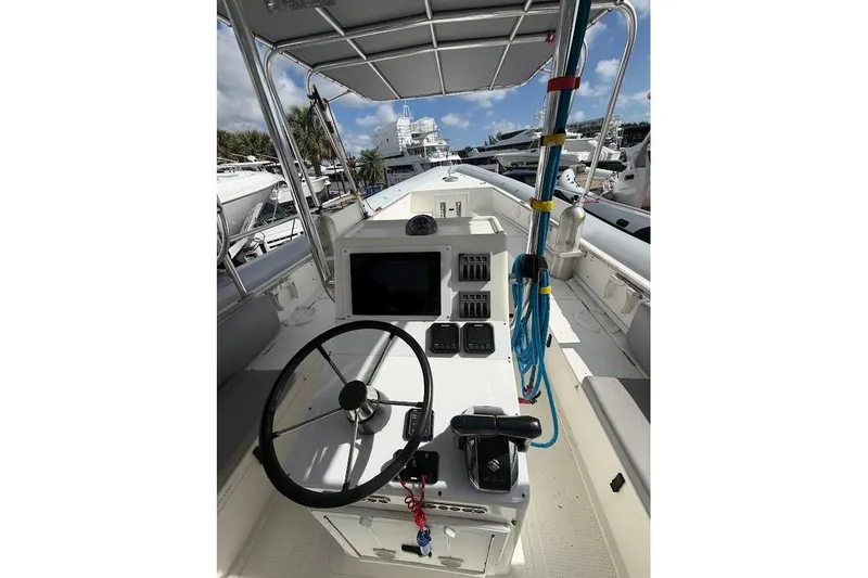 Slide: The Image of 2009 Eduardono RIB boat cockpit with steering wheel and control panel, docked at marina. - 12