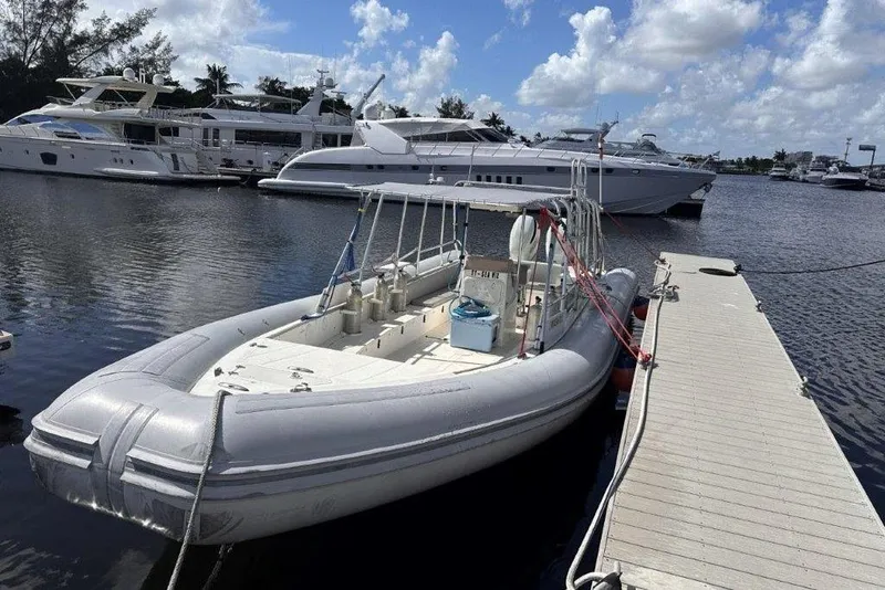 Slide: The Image of 2009 Eduardono RIB boat docked at marina, surrounded by luxury yachts under a blue sky. - 6