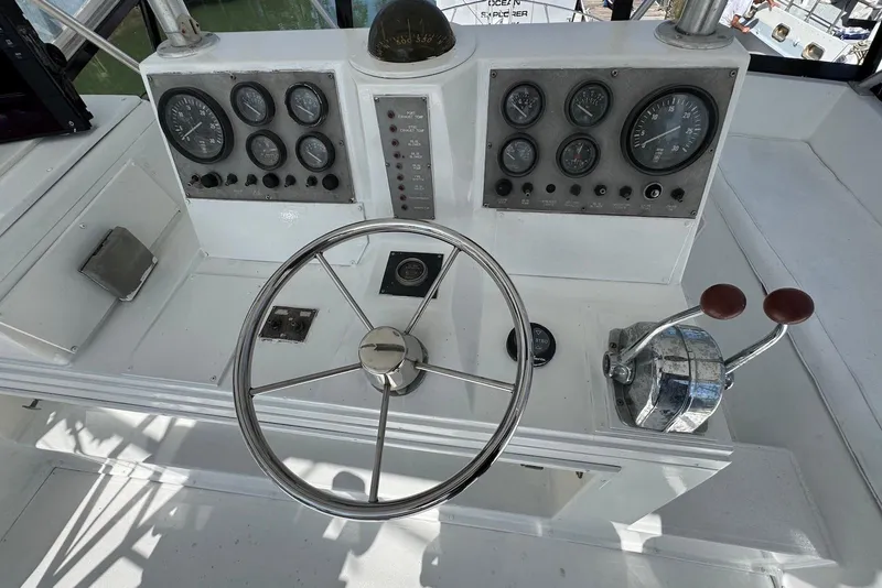 Slide: The Image of 1988 Viking 41 Convertible boat dashboard with steering wheel and control panel. - 10
