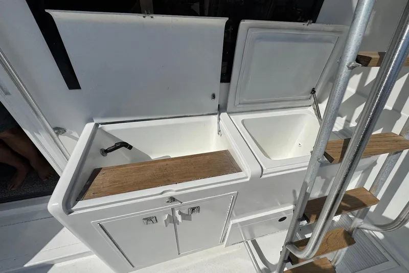 Slide: The Image of 1988 Viking 41 Convertible boat sink and storage area with wooden accents. - 11