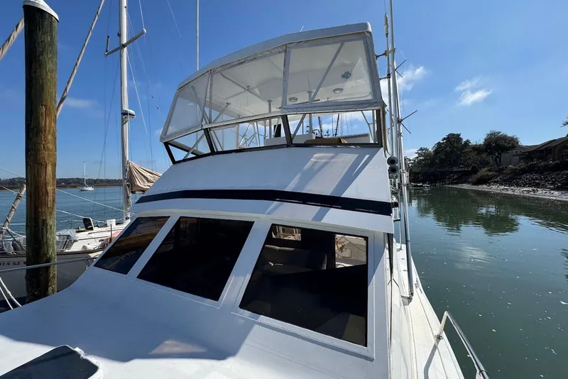 Slide: The Image of 1988 Viking 41 Convertible boat docked by calm waters under a clear blue sky. - 3