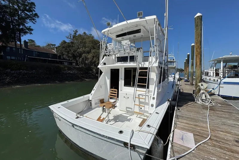 Slide: The Image of 1988 Viking 41 Convertible yacht docked at marina under clear blue sky. - 4