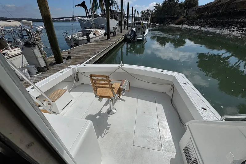 Slide: The Image of 1988 Viking 41 Convertible boat docked, featuring spacious deck and fishing chair. - 6