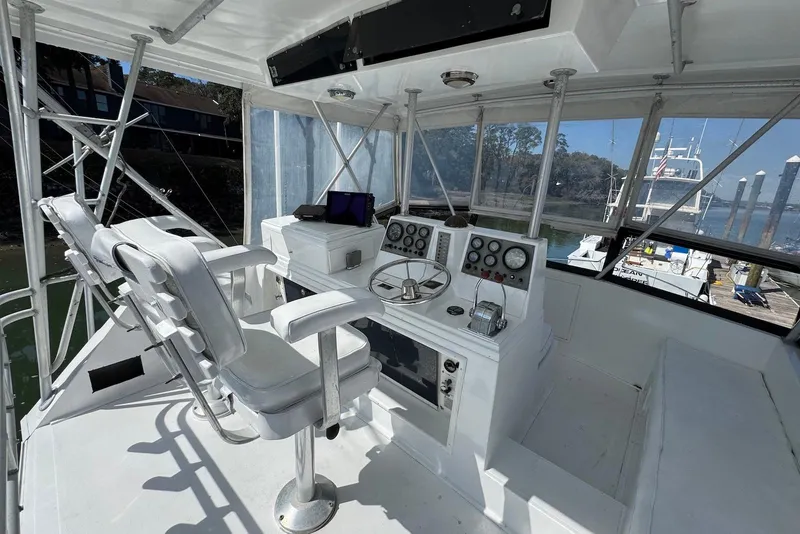 Slide: The Image of 1988 Viking 41 Convertible boat helm with dual seats and control panel, docked at marina. - 8