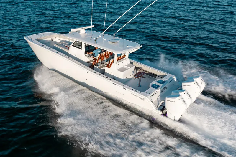 Slide: The Image of 2023 Freeman 43 boat cruising on open water with twin Mercury engines. - 13
