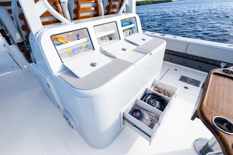 Slide: The Image of 2023 Freeman 43 boat with open storage compartments and drawers, docked on calm water. - 32