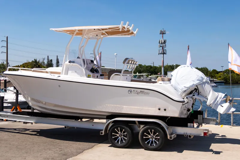 The Image of 2025 Edgewater 208CC boat on trailer, dockside, under clear blue sky. - 0