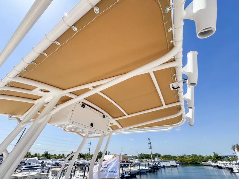 Slide: The Image of 2025 Edgewater 208CC boat canopy with rod holders, docked under clear blue sky. - 11