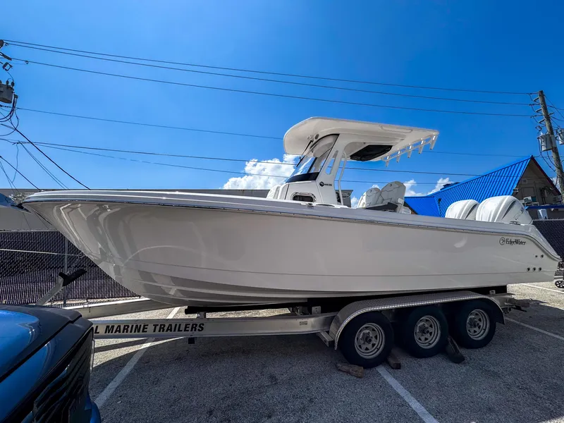 The Image of 2025 Edgewater 262CC boat on a triple-axle trailer under a clear blue sky. - 0