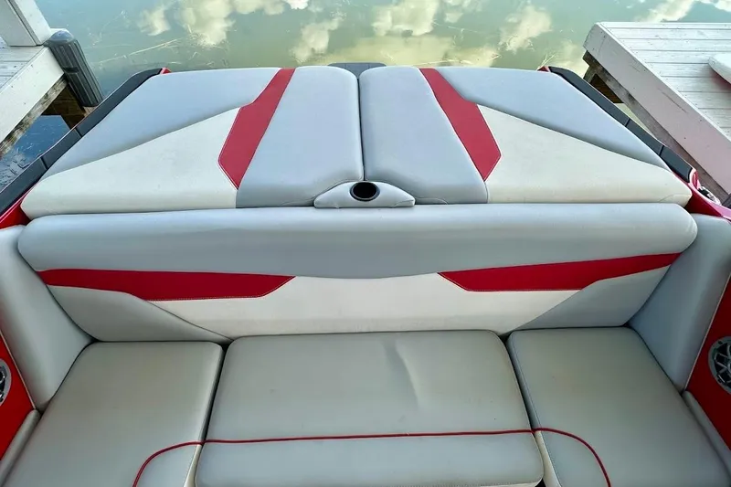 Slide: The Image of 2021 Axis A20 boat interior with red and gray seating, docked by the water. - 13