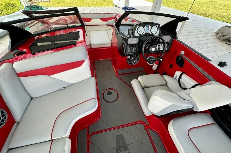 Slide: The Image of 2021 Axis A20 boat interior with red and white seating, modern dashboard, and steering wheel. - 14
