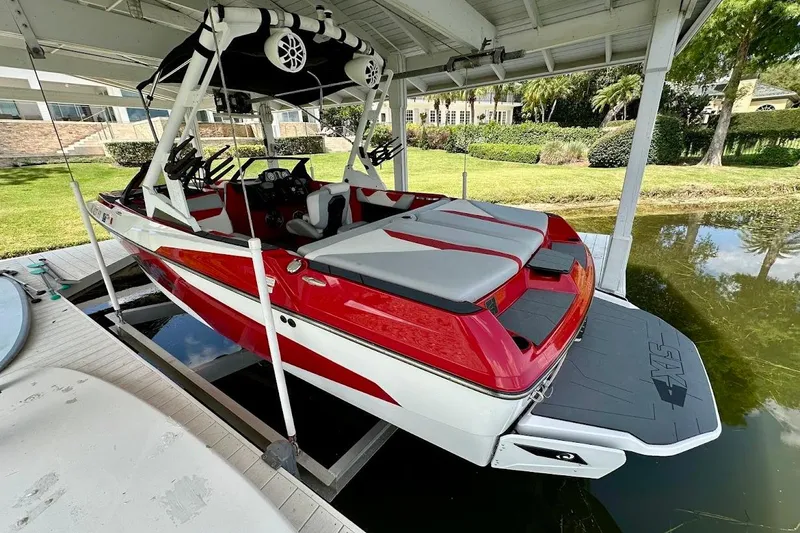 Slide: The Image of 2021 Axis A20 boat in red and white, docked under a covered structure. - 3