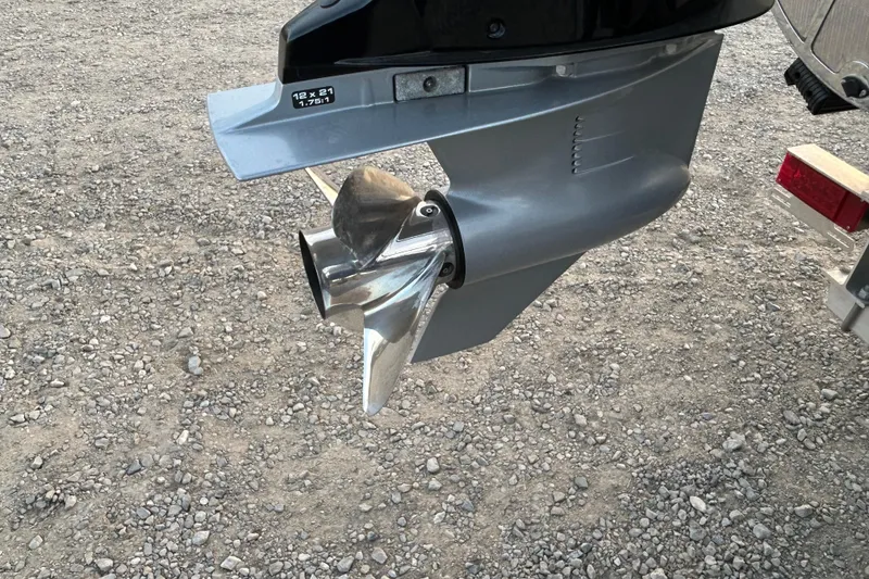 Slide: The Image of 2023 Manitou 27 XT RFXW boat propeller on gravel surface. - 19