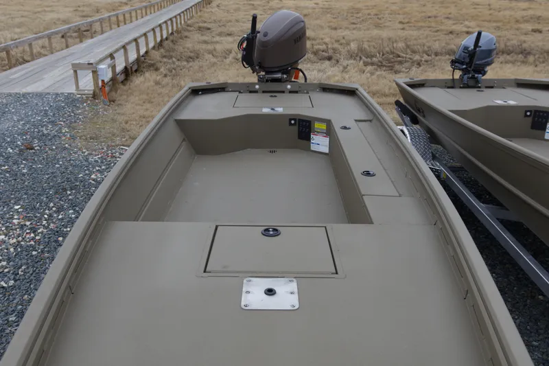 Slide: The Image of 2026 G3 Gator Tough 16 DK boat with outboard motor, docked on gravel path. - 8