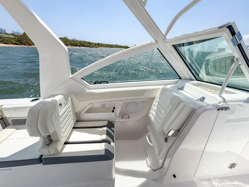 Slide: The Image of 2025 Edgewater 262 CX boat interior with white seating, ocean view, and sleek design. - 22