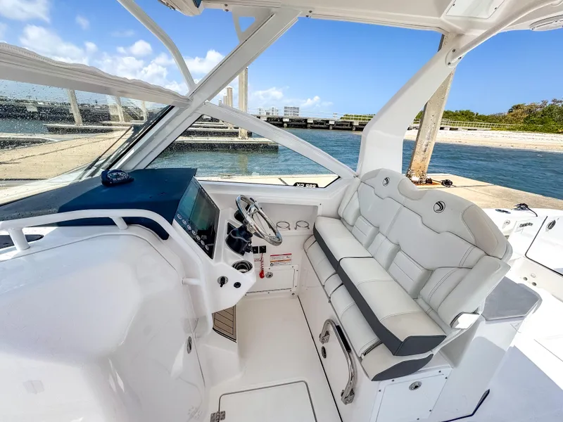 Slide: The Image of 2025 Edgewater 262 CX boat interior with sleek white seating and modern dashboard. - 9