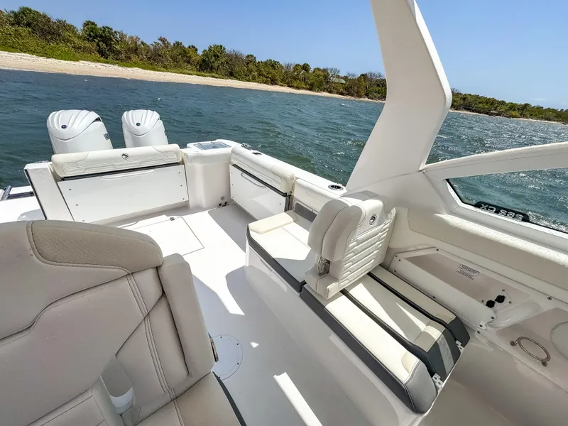 Slide: The Image of 2025 Edgewater 262 CX boat interior with seating, on a sunny day by the water. - 21