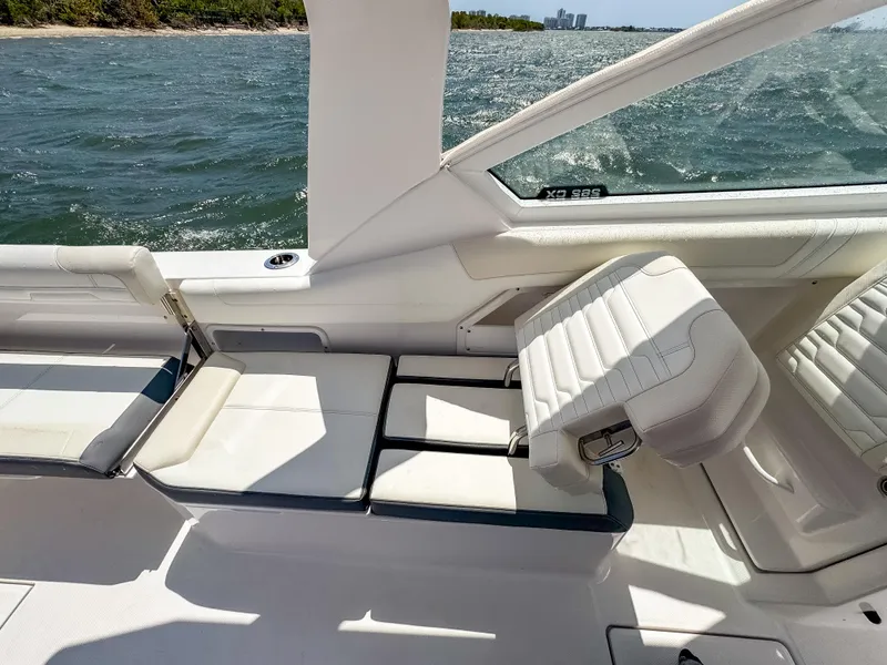 Slide: The Image of 2025 Edgewater 262 CX boat interior with white seating and ocean view. - 23