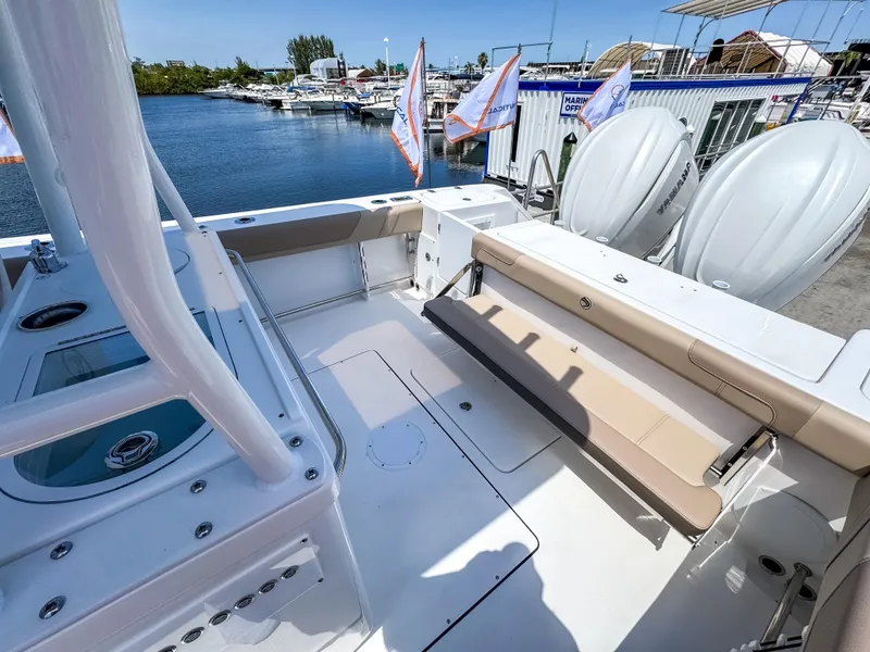 Slide: The Image of 2025 Edgewater 325CC boat with spacious deck and seating, docked near water. - 15