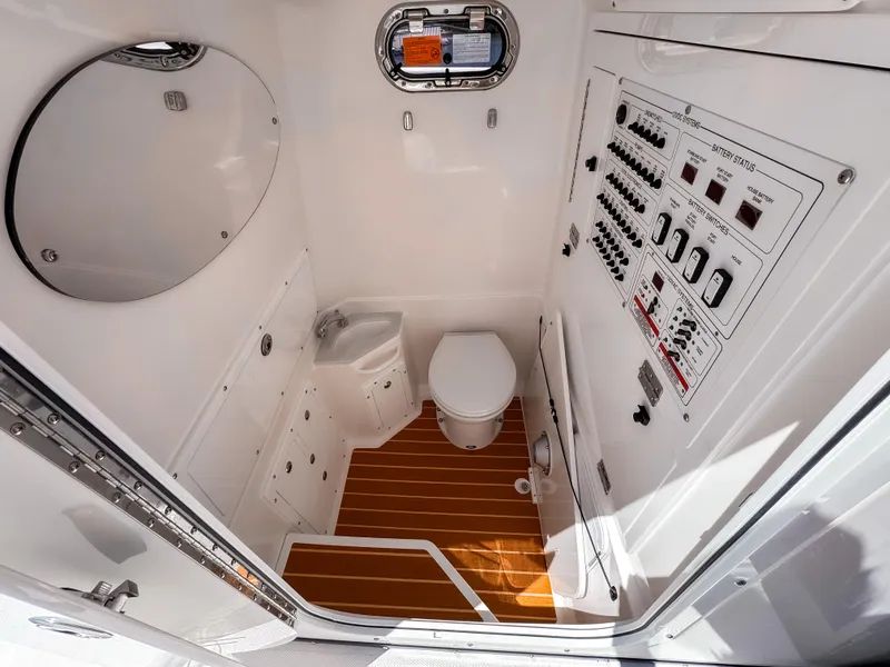 Slide: The Image of 2025 Edgewater 325CC boat interior with toilet, control panel, and wooden flooring. - 10