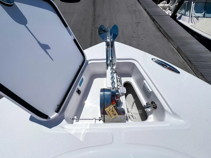 Slide: The Image of 2025 Edgewater 325CC boat anchor compartment with open hatch and chain mechanism. - 30