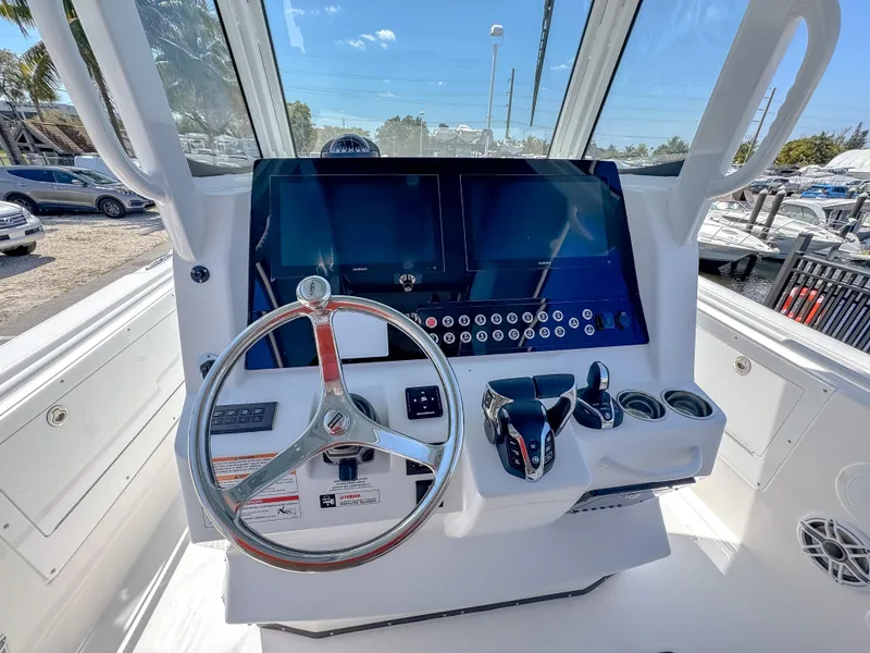 Slide: The Image of 2025 Edgewater 325CC boat dashboard with steering wheel and modern controls. - 8