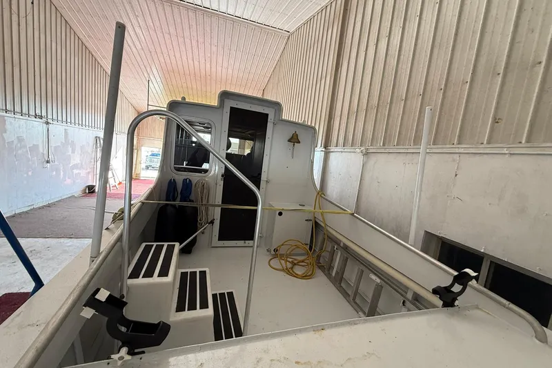 Slide: The Image of 2013 Eco-Trawler 33 interior view in a storage facility, showcasing deck and cabin entrance. - 13