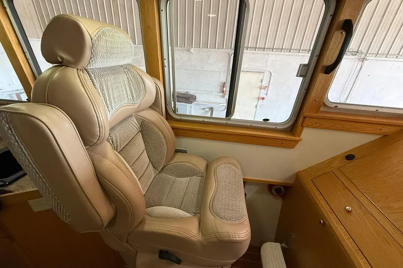 Slide: The Image of Captain's chair in 2013 Eco-Trawler 33, featuring beige upholstery and wooden interior accents. - 19